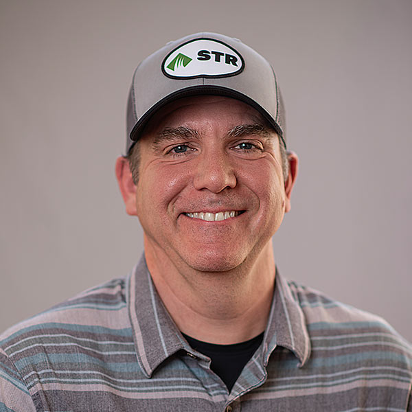 STR_Sales_Staff_Brian-2 Man smiling wearing a grey shirt with a grey hat